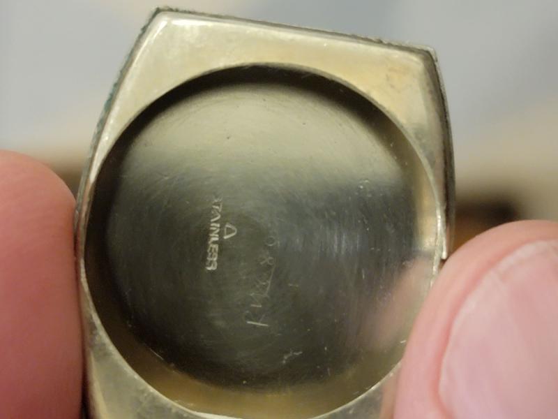 inside of case. "Stainless" stamp, triangle (?) stamp or etching, faint #s and letters